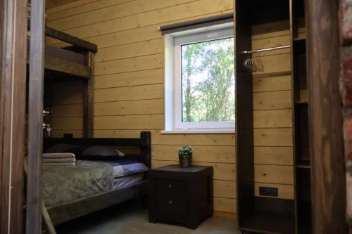 a bedroom with a bed and a window at Vertikāles Austrumi in Cenkone