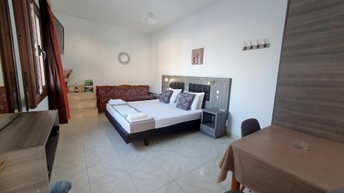 a bedroom with a bed and a couch in a room at Lindos Panorama in Líndos