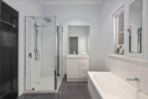 a bathroom with a shower and a tub and a sink at Bendigo Signature Accommodation Group Holiday in Bendigo