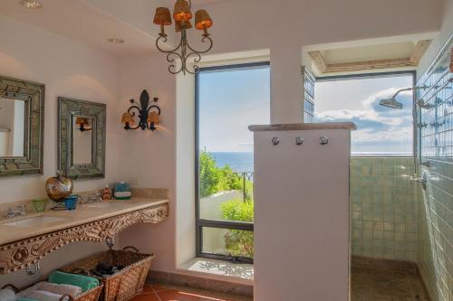 een badkamer met douche, wastafel en raam bij Villa Turquesa 10BR by Cabo Villas in Cabo San Lucas