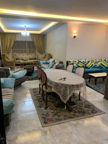 a living room with a table and chairs and a couch at شقة للإيجار اليومي مفروشه سوبر لوكس in Manshīyat as Sādāt