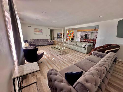 a large living room with a large couch and chairs at Ultimate Luxury Villa - Pool, Sauna, Hot Tub & More in Paterson