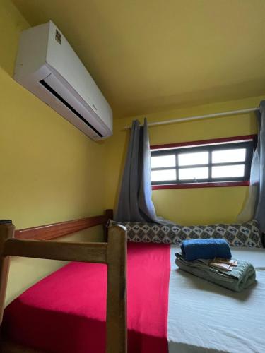 a bedroom with a bunk bed with a window at Pousada Morango das Palmas in Praia de Palmas