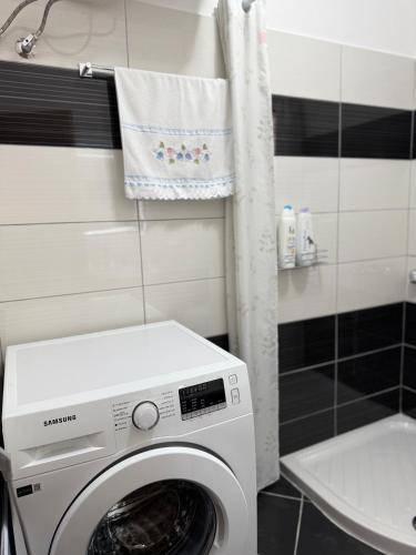 a washing machine in a bathroom next to a sink at Tranquility Apartment in Sarandë