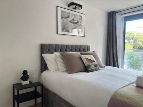a bedroom with a large white bed with a window at Peaceful, cosy - modern 2 Bedroom entire Flat in Canary Wharf Close to the 02 in London