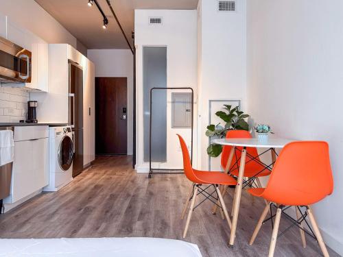 a dining room with orange chairs and a table at City & River View Suite - The Wharf DC by Monthier in Washington, D.C.