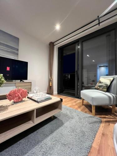 a living room with a couch and a tv at Peaceful, cosy - modern 2 Bedroom entire Flat in Canary Wharf Close to the 02 in London
