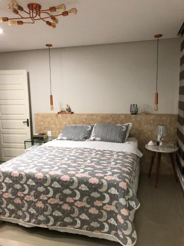 a bedroom with a bed with a floral bedspread at Linda casa - 03 quartos - perto do centro in Garanhuns