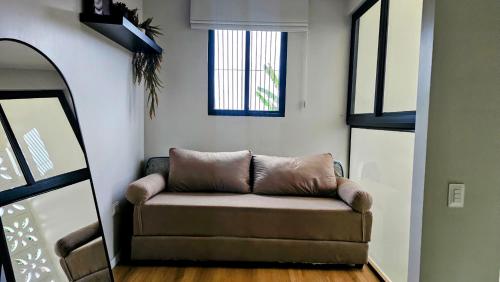 een bank in een woonkamer met een raam bij Linda casa em Garanhuns-PE in Garanhuns