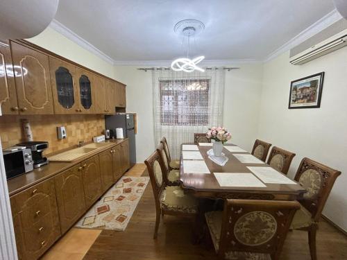 una sala da pranzo con tavolo e cucina di Top Guesthouse a Shkodër