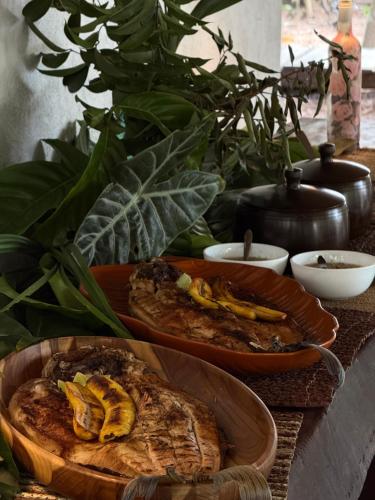 a table with two plates of bread and bananas at Choupanas Awa - All inclusive em Anavilhanas in Novo Airão