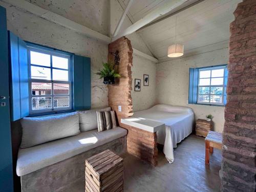 a living room with a couch and a bed at A Casinha - Perdões, Minas Gerais in Perdões