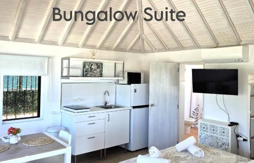 a kitchen with a white refrigerator and a sink at Mandala Bungalows - Adults Only in Los Caños de Meca