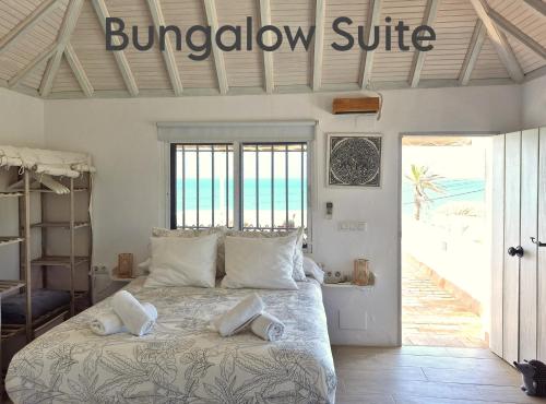 a bedroom with a large bed with a window suite at Mandala Bungalows - Adults Only in Los Caños de Meca