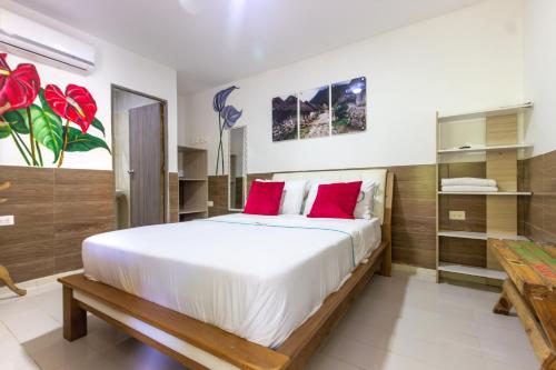 a bedroom with a large white bed with red pillows at MINCA Chunuu - glamping - coworking MINCA in Minca