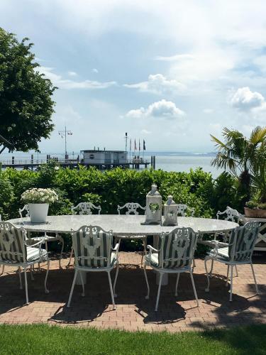 a white table and chairs with a view of the ocean at Boutique Hotel Villa am See in Hagnau
