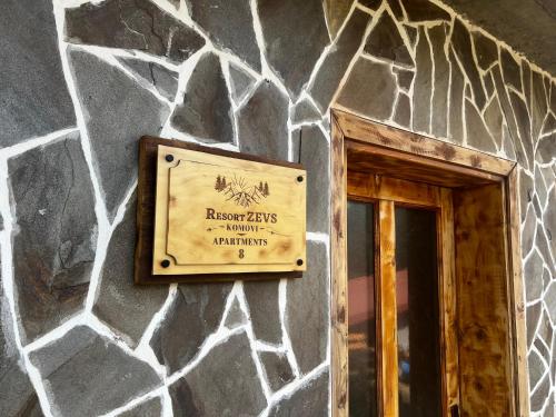 a sign on the side of a stone wall at Resort Komovi in Kravlja