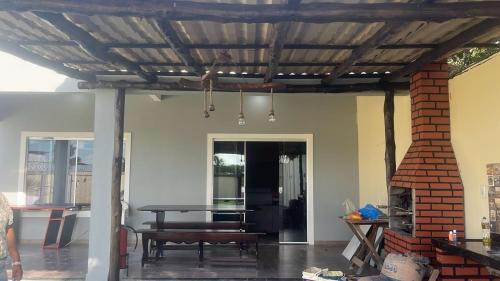 a patio with a table and a brick fireplace at Casa Salinas in Salinópolis