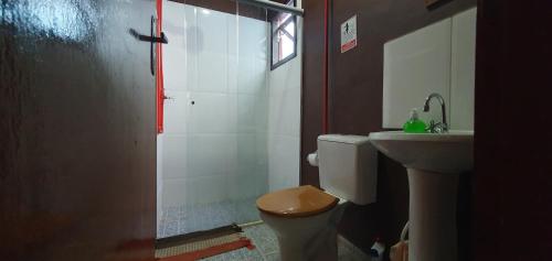 Un baño con ducha, inodoro y lavabo. en Tahoma Chale Rustico côr Café e vermelho Prumirim Paraiso, en Ubatuba