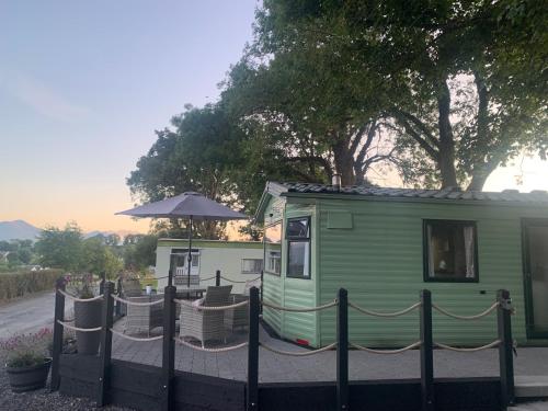 a green trailer with a fence and an umbrella at Town View in Killarney