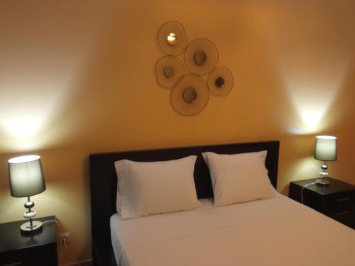 a bedroom with a white bed with two lamps at Apartamento Xelb in Silves