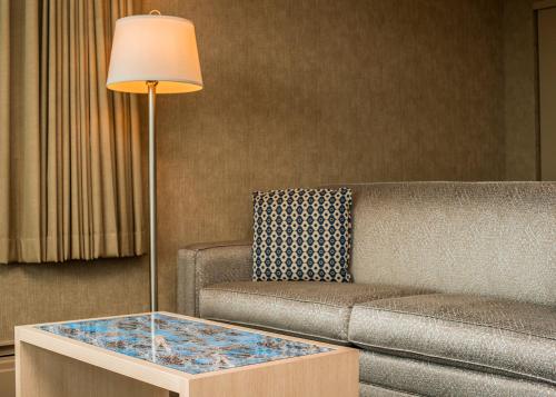 a living room with a couch and a table with a lamp at Blue Horizon Hotel in Vancouver