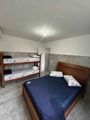 a bedroom with a bed and two bunk beds at Apartamento em Bertioga in Bertioga