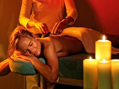 a woman getting a massage in a room with candles at Rebhan's Klassik in Stockheim Oberfranken