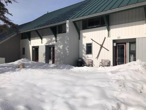 a building with a large clock on it in the snow at Village Green 4D in Stowe