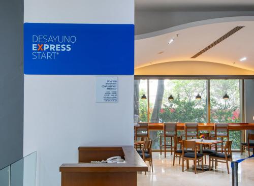 a restaurant with tables and chairs and a sign that reads design unto expressstart at Holiday Inn Express Mexico Reforma by IHG in Mexico City
