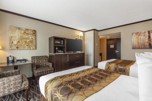a hotel room with two beds and a television at Best Western Wayside Inn in Wetaskiwin