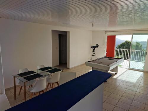 a room with a ping pong table and a telescope at HARMONY Appart Type Penthouse avec vue imprenable in Bois la Charles