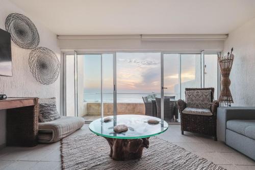 a living room with a table and a view of the ocean at Maravilloso departamento frente al mar, Acapulco in Acapulco