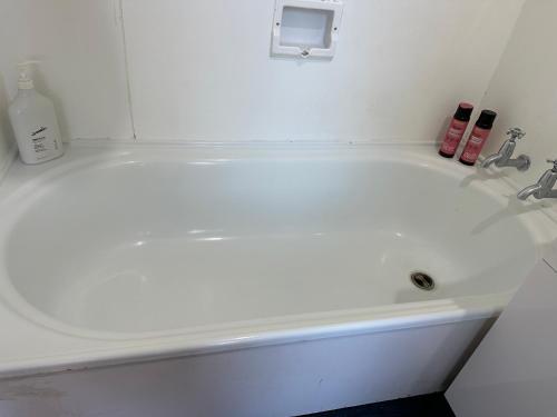 a white bath tub in a white bathroom at One Bedroom Villa Spacious Room,Amazing Location All Perks in Auckland