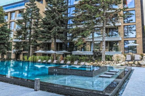 a swimming pool in front of a tall building at Luxury Ap Blanka - Pool & Panorama in Azur in St. St. Constantine and Helena