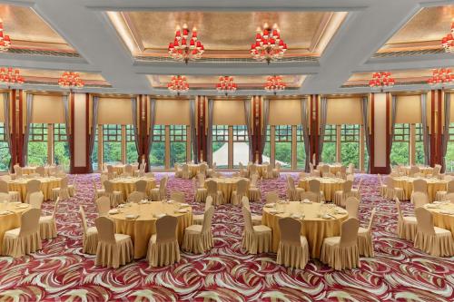 a ballroom with tables and chairs in a room with windows at Dongguan Marriott Hotel in Dongguan