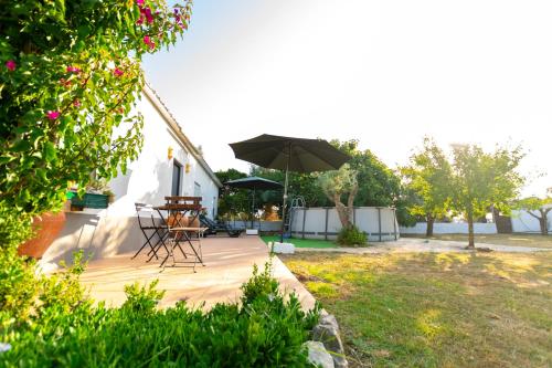 a wooden deck with a table and an umbrella at Natur - Quinta Nª Srª da Conceição - T4 - Golegã in Golegã
