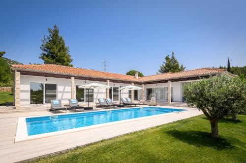 a villa with a swimming pool and a house at Villa Stella - heated pool, jacuzzi & sauna in Šibenik