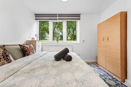 a bedroom with a bed and a dresser and two windows at *Brand New 1 Bedroom Flat in Central London* in London