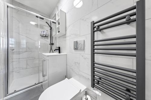 a white bathroom with a shower and a toilet at *Brand New 1 Bedroom Flat in Central London* in London
