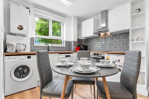 a kitchen with a table and chairs and a washer and dryer at *Brand New 1 Bedroom Flat in Central London* in London