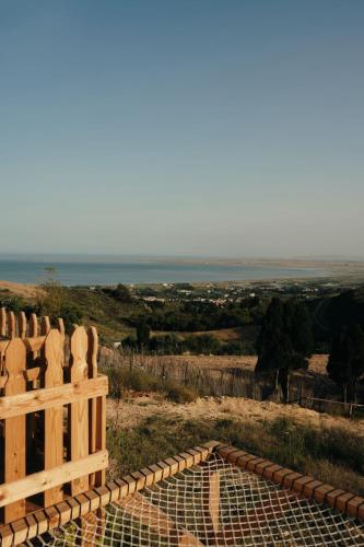 a wooden fence on a hill with a view of the ocean at Ghar El Melh Outdoors in Raʼs al Jabal