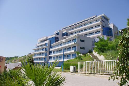 オブゾルにあるAurora apartments on the beachの青い窓のある大きな白い建物