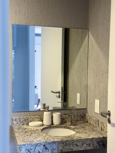 a bathroom with a sink and a large mirror at Departamento en Luque cerca a Asunción 210 in Luque