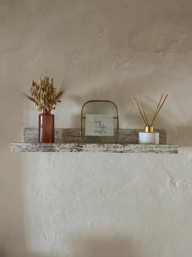 a shelf with two plants and a sign on it at Casa na aldeia in Albernoa