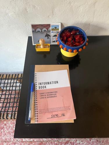a book and a bowl of fruit on a table at Casa na aldeia in Albernoa