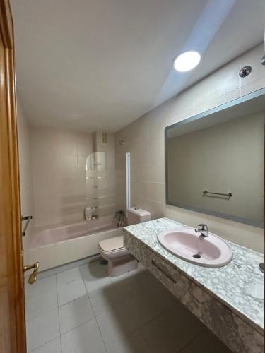 a bathroom with a sink and a toilet and a mirror at Apartamento en Golf Center Pueblo in Roquetas de Mar