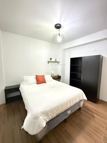 a bedroom with a large white bed and a fireplace at Hostal Ramé in Panajachel