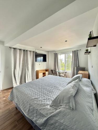 a bedroom with a large bed in front of a window at Hostal Ramé in Panajachel