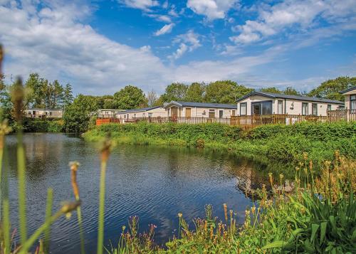 a river in front of a row of houses at Woodland Vale Holiday Park in Ludchurch